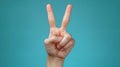 A close-up studio shot capturing a hand raising two fingers, symbolizing a gesture of peace, vict