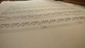 Close up studio shot of classical piano. Shot inside the piano with composition paper sheets with musical notes laying