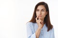 Close-up studio shot curious, serious-looking businesswoman pondering important business choice, look sideways copy