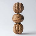 Three whole walnuts stacked vertically on a white background Royalty Free Stock Photo