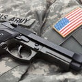 Close up studio shot of a handgun over USA solder's uniform with shoulder patch on it Royalty Free Stock Photo