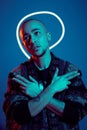 Studio shot of a young tattoed bald man posing against a blue background. 90s style. Royalty Free Stock Photo