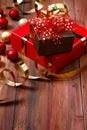 Close up studio shot of small brown present gift with gold dot on red ribbon bow tie placed on big paper wrapped box on dark brown Royalty Free Stock Photo