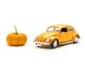 Close-up studio shot small orange toy car with mini pumpkin isolated on white Royalty Free Stock Photo