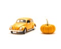 Close-up studio shot small orange toy car with mini pumpkin isolated on white Royalty Free Stock Photo