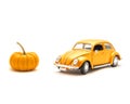 Close-up studio shot small orange toy car with mini pumpkin isolated on white Royalty Free Stock Photo