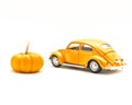 Close-up studio shot small orange toy car with mini pumpkin isolated on white Royalty Free Stock Photo