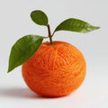 A Textured Orange Sphere Adorned with Green Leaves and a Branch on a White Background Royalty Free Stock Photo