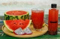 Close up studio shot of sweet delicious healthy sliced watermelon and fresh ripe cold dragon fruit juice in glass placed on wood Royalty Free Stock Photo