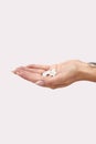 Close Up Studio Shot Of Woman Holding Medication In Palm Of Hand