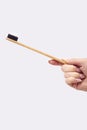 Close Up Studio Shot Of Woman Holding Sustainable Wooden Toothbrush