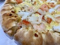 Close-up of stuffed seafood pizza with cheese, onion, prawn, squid, and crab stick. Stuffed crust pizza with Cheese Royalty Free Stock Photo