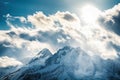close-up of stunning mountain range with clouds, sun, and blue skies Royalty Free Stock Photo