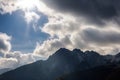 close-up of stunning mountain range with clouds, sun, and blue skies Royalty Free Stock Photo
