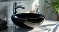 Close up of stylish black ceramic round vessel sink and chrome faucet on white vanity Royalty Free Stock Photo