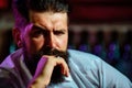 Close up of a stylish handsome bearded man enjoying a brandy or whiskey.