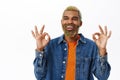 Close up of stylish hipster guy shows okay sign. Handsome african american man with yellow beard and hairstyle, makes ok Royalty Free Stock Photo