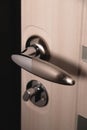 Close up of stylish silver chrome door handle on modern interior door. Stylish light brown door with frosted glass Royalty Free Stock Photo