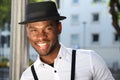 Close up stylish young african american man smiling with suspenders and hat Royalty Free Stock Photo
