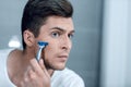 Close up. stylish young man shaves his face. Royalty Free Stock Photo