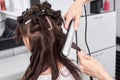 Close up of stylist`s hand using curling iron for hair curls Royalty Free Stock Photo