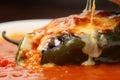 Close-up of succulent Chiles Rellenos oozing with melted cheese and surrounded by a rich, tangy tomato sauce