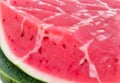 A close-up of a succulent watermelon slice, its juicy, pink flesh glistening in the sun.