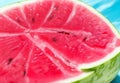 A close-up of a succulent watermelon slice, its juicy, pink flesh glistening in the sun.