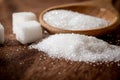 Close up a sugar cubes and cane in wooden spoon on the table Royalty Free Stock Photo