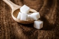 Close up sugar cubes in wooden spoon on the table Royalty Free Stock Photo