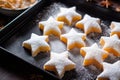 close-up of sugar-dusted, star-shaped cookies on a baking tray