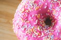Sugar sprinkled pink donut glace, close up picture Royalty Free Stock Photo