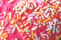Sugar sprinkled pink donut glace, close up picture