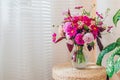 Close up of summer bouquet of pink roses dahlias flowers in vase on straw wicker pad. Interior and decor at home. Space Royalty Free Stock Photo