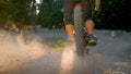 CLOSE UP: Sunbeams shine on gravel path as downhill cyclist rides past camera.