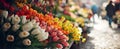 Close up of a sunlit florist stand at a flower market where colorful tulips and narcissus are being sold