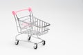 Close up of supermarket grocery push cart for shopping with black wheels on white background. Concept of shopping. Royalty Free Stock Photo