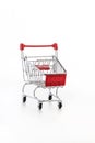 Close up of supermarket grocery push cart for shopping with black wheels and plastic elements on handle isolated on white Royalty Free Stock Photo