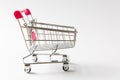 Close up of supermarket grocery push cart for shopping with black wheels and pink plastic elements on handle isolated on Royalty Free Stock Photo