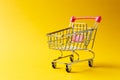 Close up of supermarket grocery push cart for shopping with black wheels and red plastic elements on handle isolated on Royalty Free Stock Photo