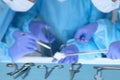 Close up of surgical tools while group of surgeons at work in operating theater Royalty Free Stock Photo