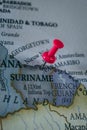 Close up of Suriname pin pointed on the world map with a pink pushpin Royalty Free Stock Photo