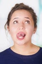 Close up of surprise beautiful woman touching her teeth with their tonge, after a miss lip, in a white background