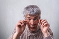 A close-up of surprised adult with gray hair and wrinkles wearing glasses. A senior man touching his eyeglasses looking with wide Royalty Free Stock Photo