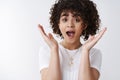 Close up surprised charismatic curly-haired girl react incredible amusing surprise shout wow open mouth impressed raise