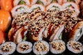 Close up of sushi rolls drizzled with sauce and sprinkled with sesame seeds. Royalty Free Stock Photo