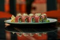 Close up of sushi rolls with raw tuna fish on white plate on a table of Japanese restaurant Royalty Free Stock Photo