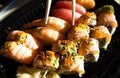 Close-up of sushi rolls with red caviar, salmon, tuna, and avocado isolated on black background. Royalty Free Stock Photo