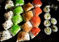 Close-up of sushi rolls with red caviar, salmon, tuna, and avocado isolated on black background. Royalty Free Stock Photo