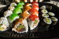 Close-up of sushi rolls with red caviar, salmon, tuna, and avocado isolated on black background. Royalty Free Stock Photo